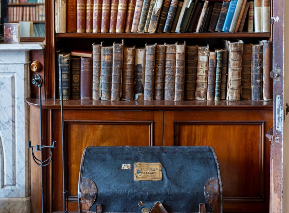 Historic library display at Ardgillan Castle featuring vintage books and travel trunk