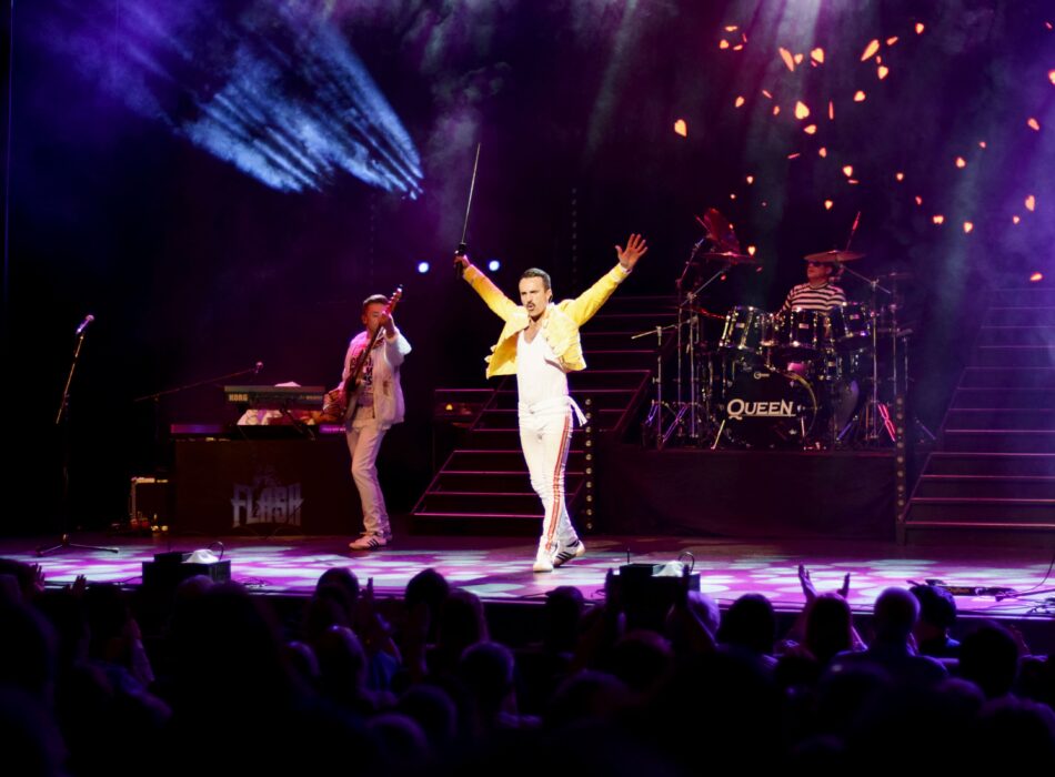Queen tribute band performing in front of a live audience.
