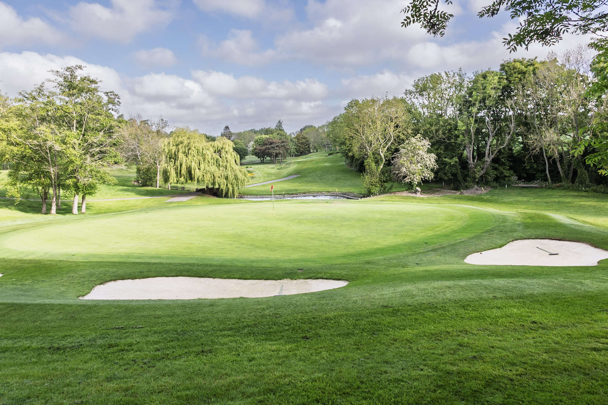beautifully maintained green at Forrest Little Golf Club, framed by pristine bunkers, mature trees, and a peaceful water feature. Set within a tranquil parkland landscape, the course offers a scenic and rewarding golfing experience in the heart of Fingal.